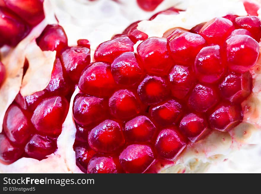 The broken red ripe pomegranate (focus on the foreground). The broken red ripe pomegranate (focus on the foreground)