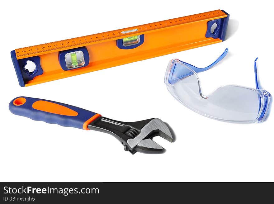 Safety glasses, a wrench and a ruller isolated on a white background. Safety glasses, a wrench and a ruller isolated on a white background