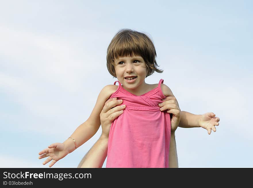 White man picking up his little girl against blue sky. White man picking up his little girl against blue sky