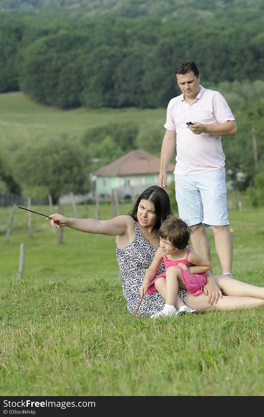 Young father callying by mobile and his family playing in summer season. Young father callying by mobile and his family playing in summer season