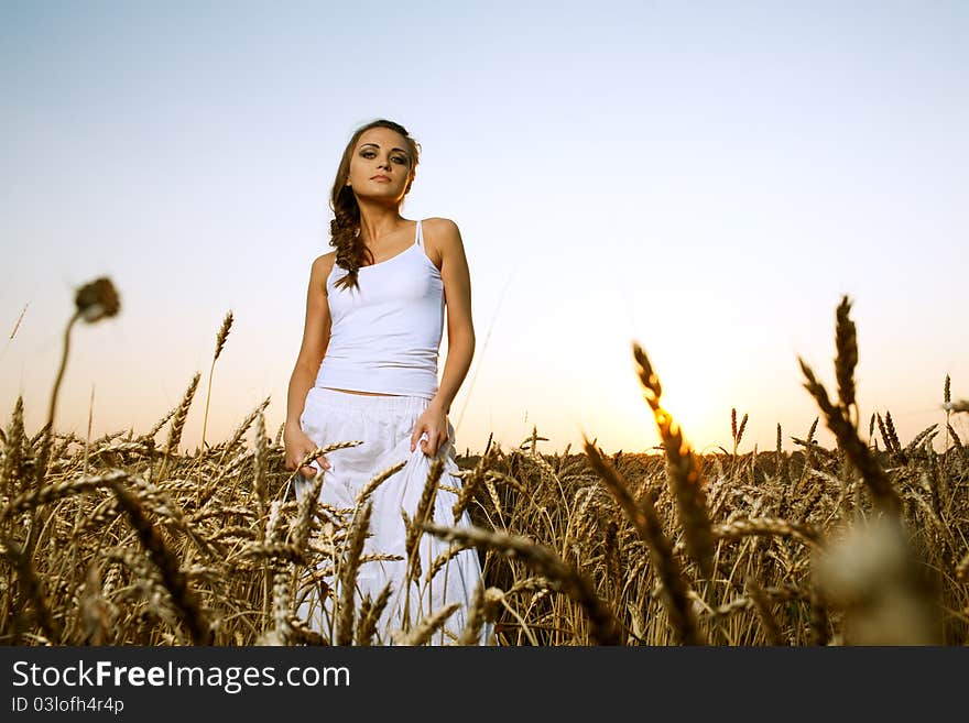 Woman in wheat field under blue sky