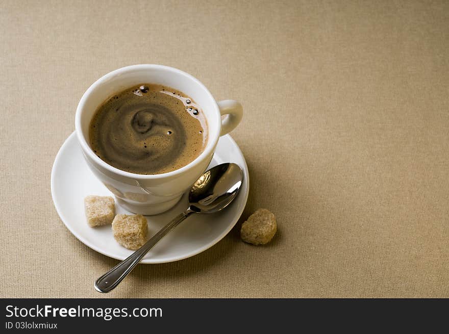 Black coffee cup with brown sugar over textured background