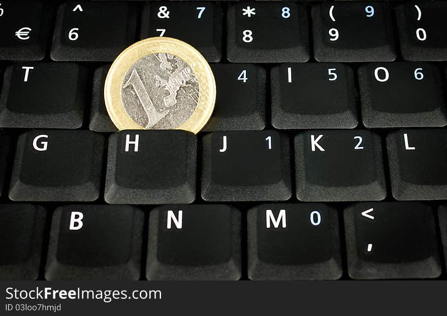 Euro coin on laptop keyboard