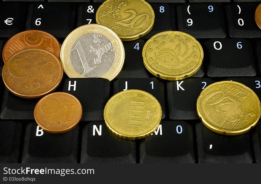 Euro coins on laptop keyboard