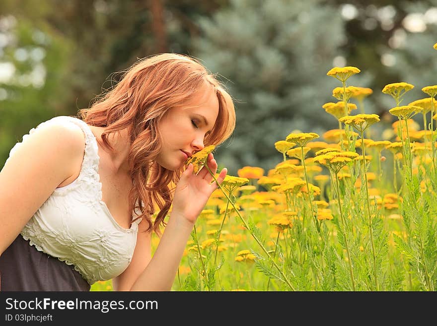 Pretty girl outdoors smells a flower. Pretty girl outdoors smells a flower