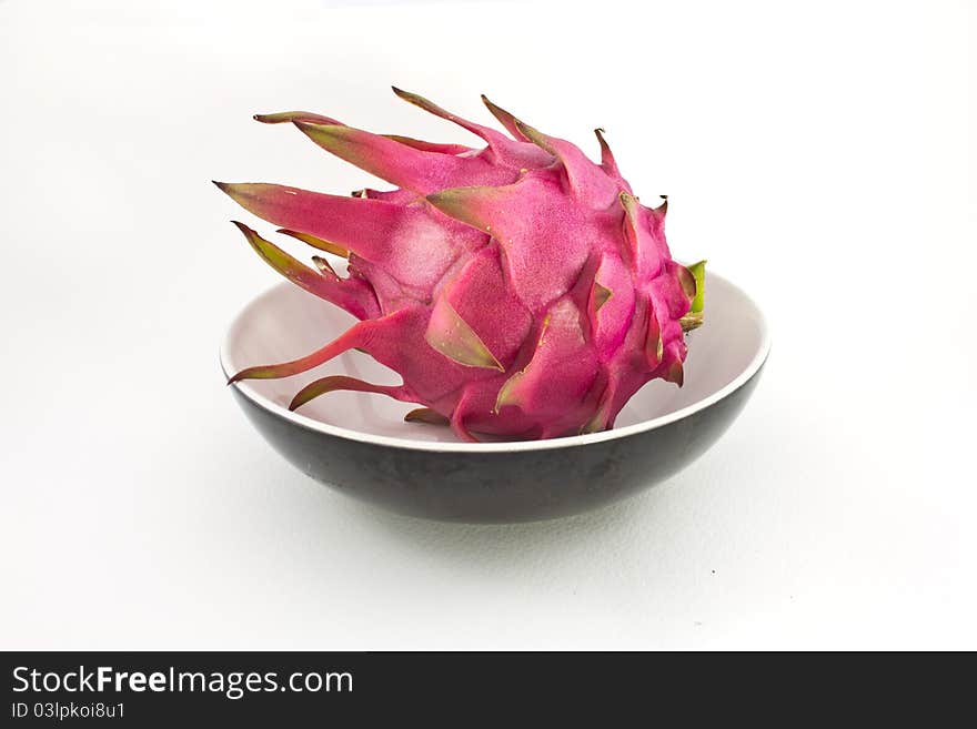 Red organic dragon fruit in cup on white background