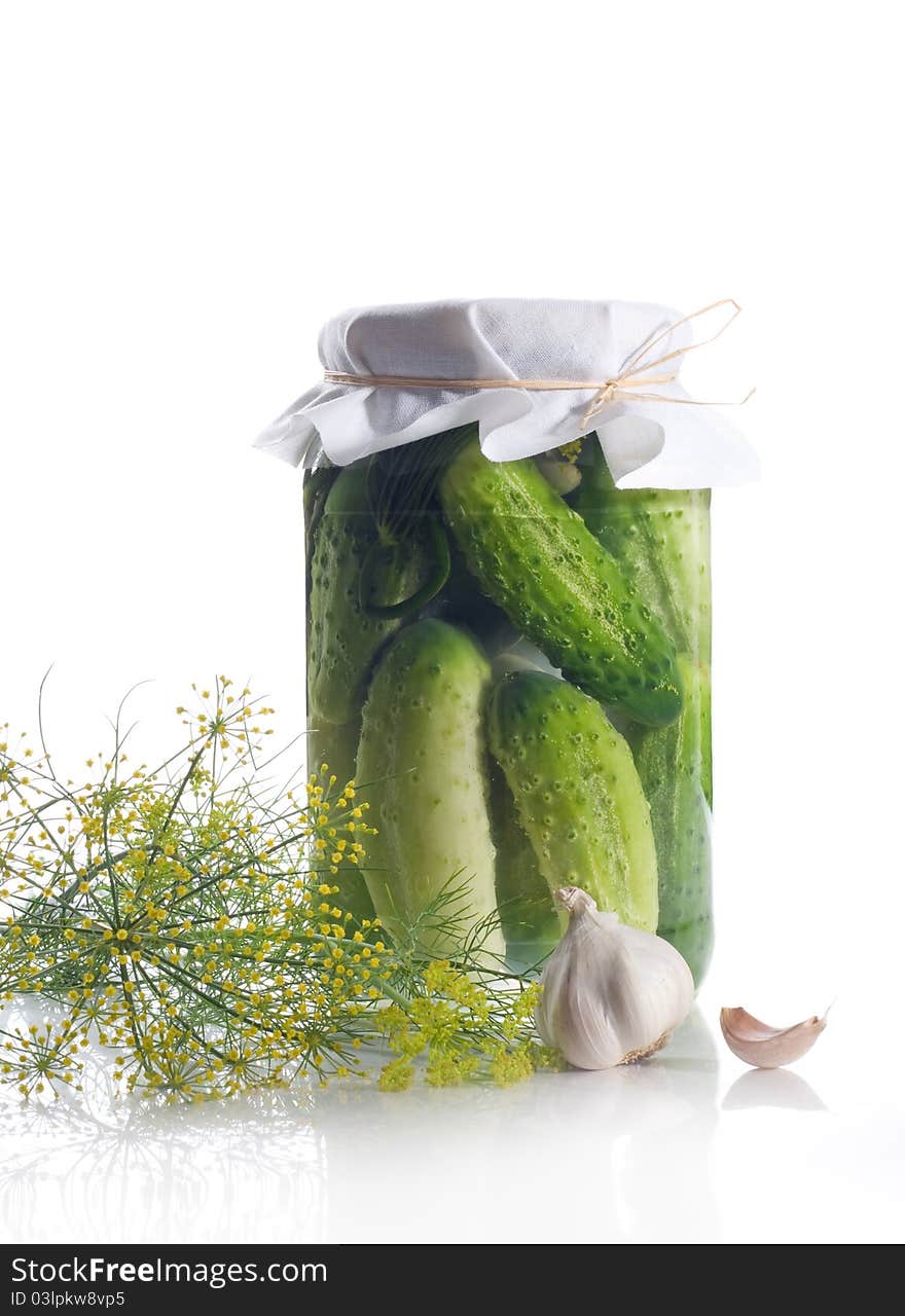 Jar of pickled cucumbers with dill and garlic on a white background. Jar of pickled cucumbers with dill and garlic on a white background.