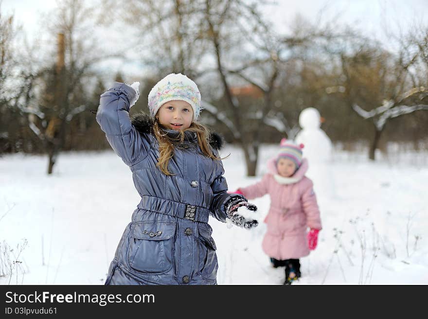 Two little girls playing snowballs