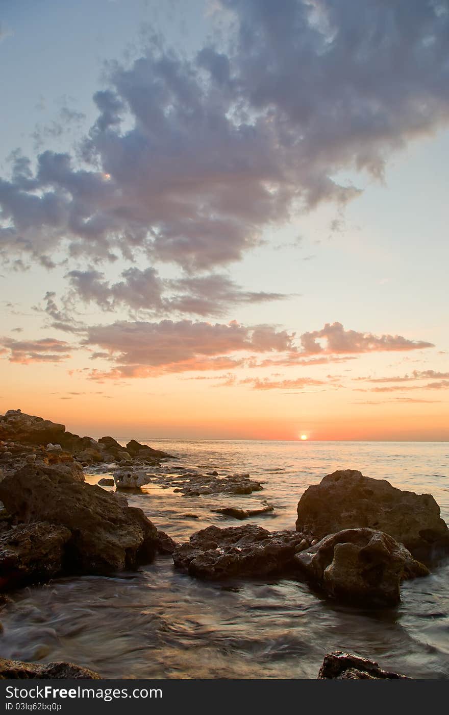 Beautiful sunset against the sea and rocks. Beautiful sunset against the sea and rocks