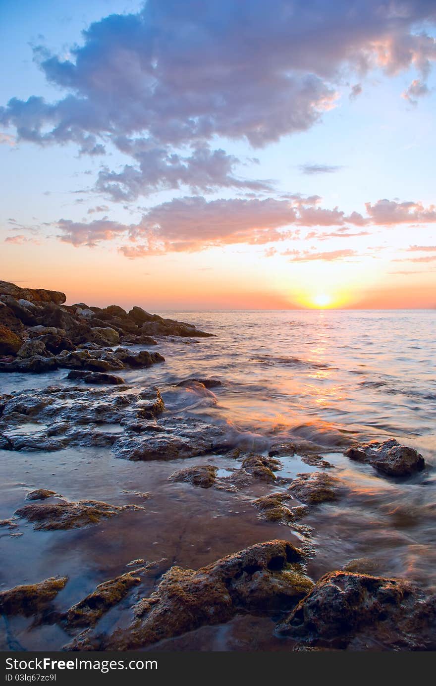 Beautiful sunset against the sea and rocks. Beautiful sunset against the sea and rocks