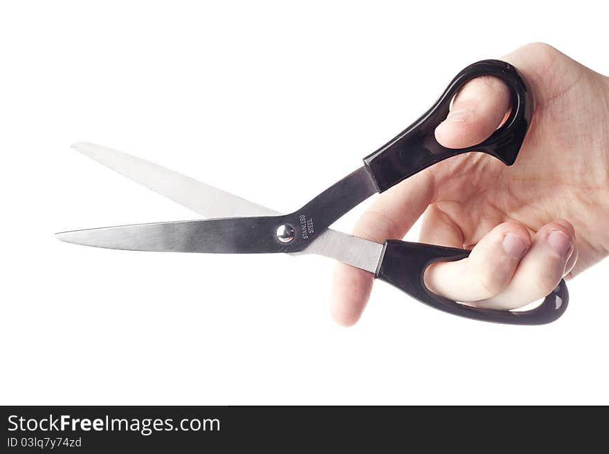 A hand holding a pair of black scissors against a white background