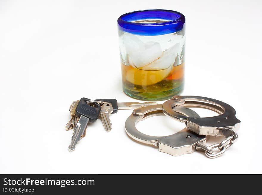 Glass of whiskey, keys, and a set of handcuffs. Glass of whiskey, keys, and a set of handcuffs