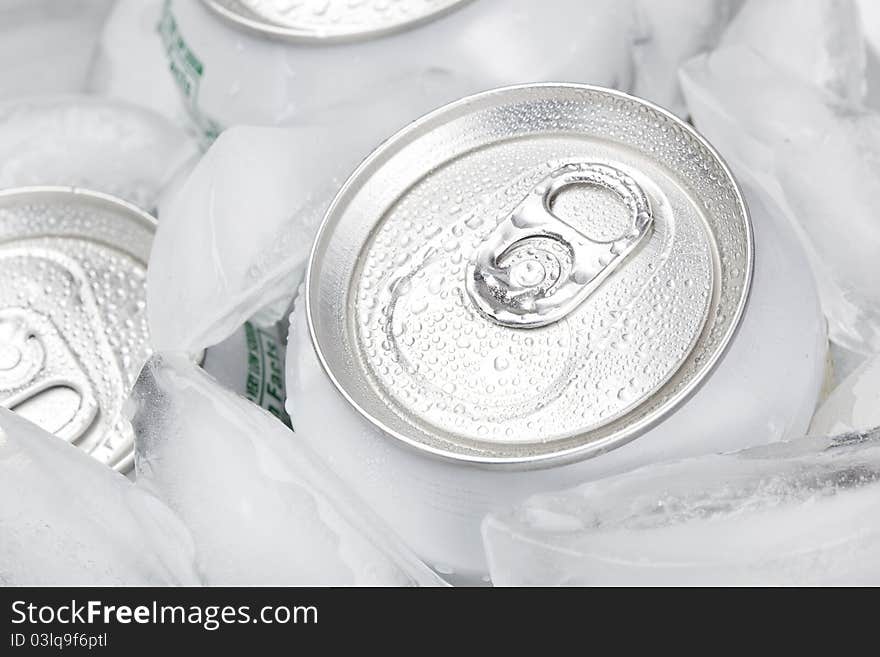 A group of soda cans in a container of ice