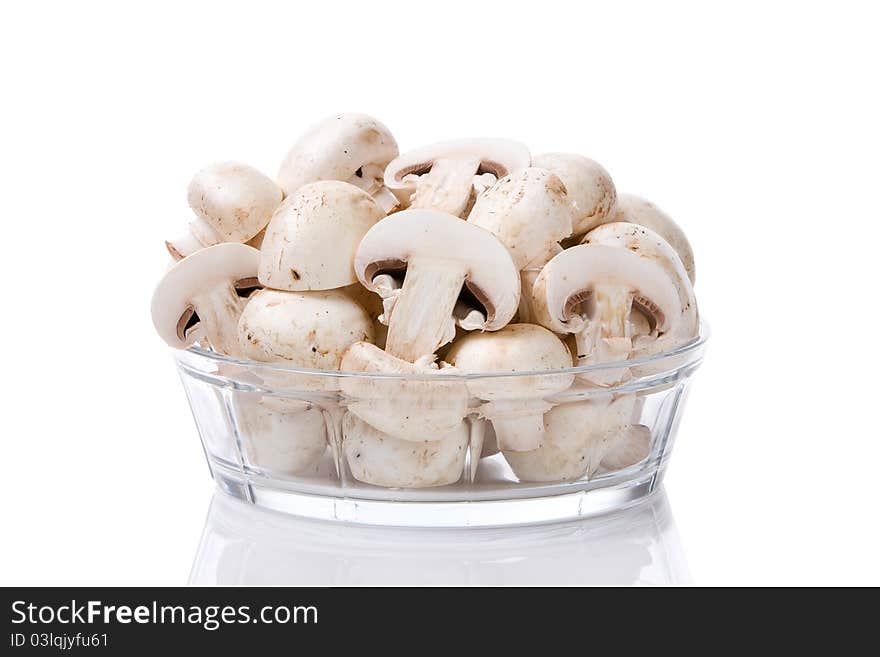 Bunch of sliced mushrooms in a glass bowl isolated on white background