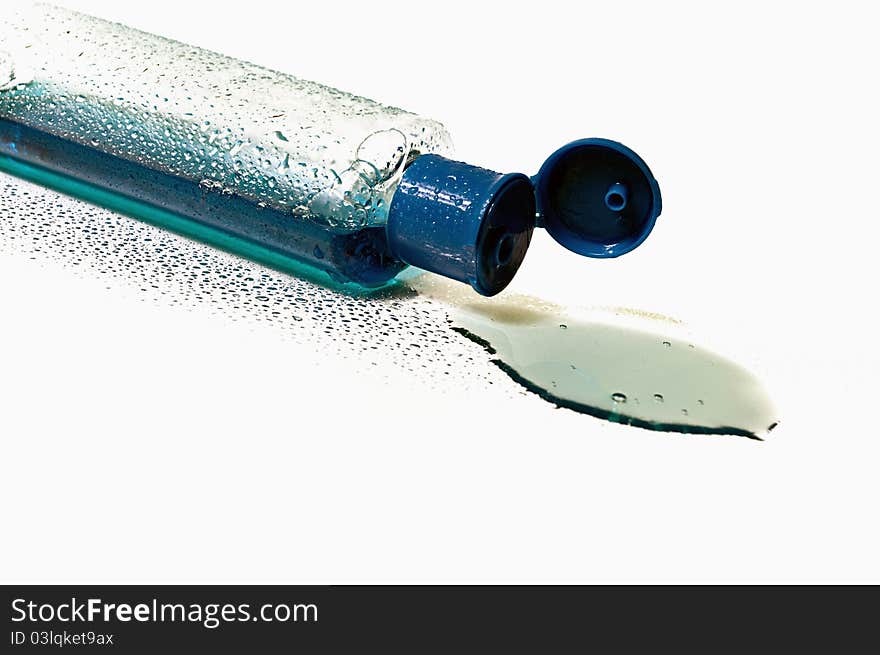 Bottle of blue liquid that spilled wet, isolated. Bottle of blue liquid that spilled wet, isolated