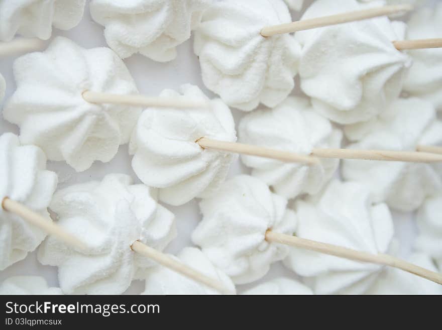 White small meringue on skewer. White small meringue on skewer