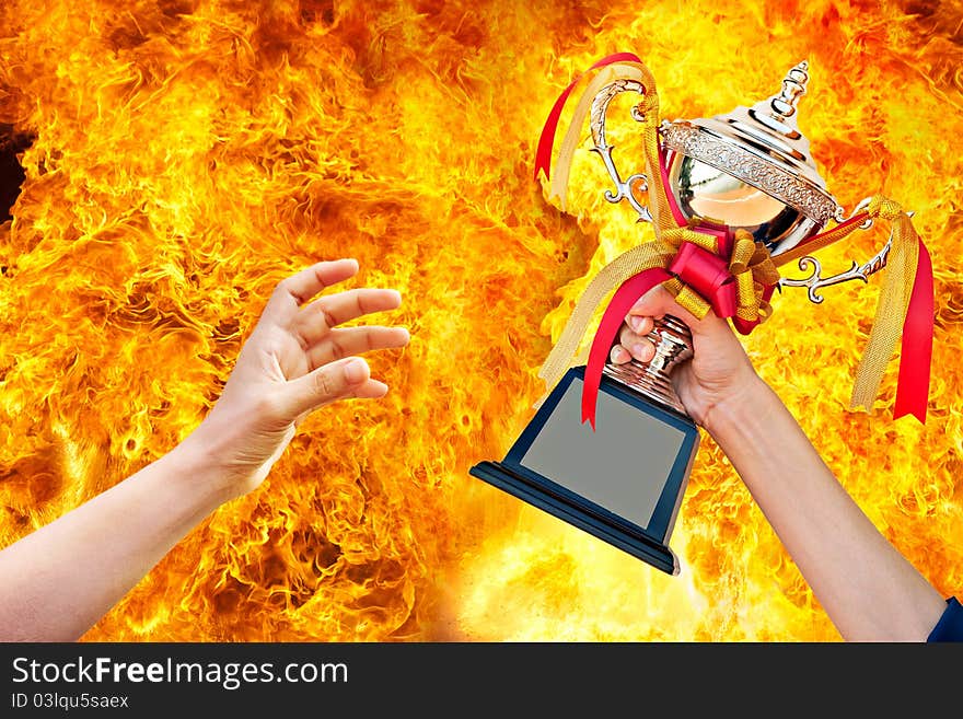 Cup with ribbon in hand on fire background. Cup with ribbon in hand on fire background