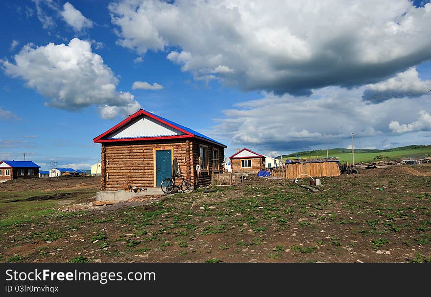 Log Cabin under blue sky and white clouds.