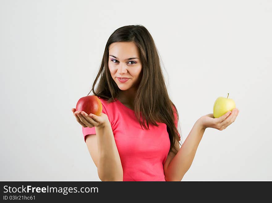 A pretty woman holding two colorful ripe apples