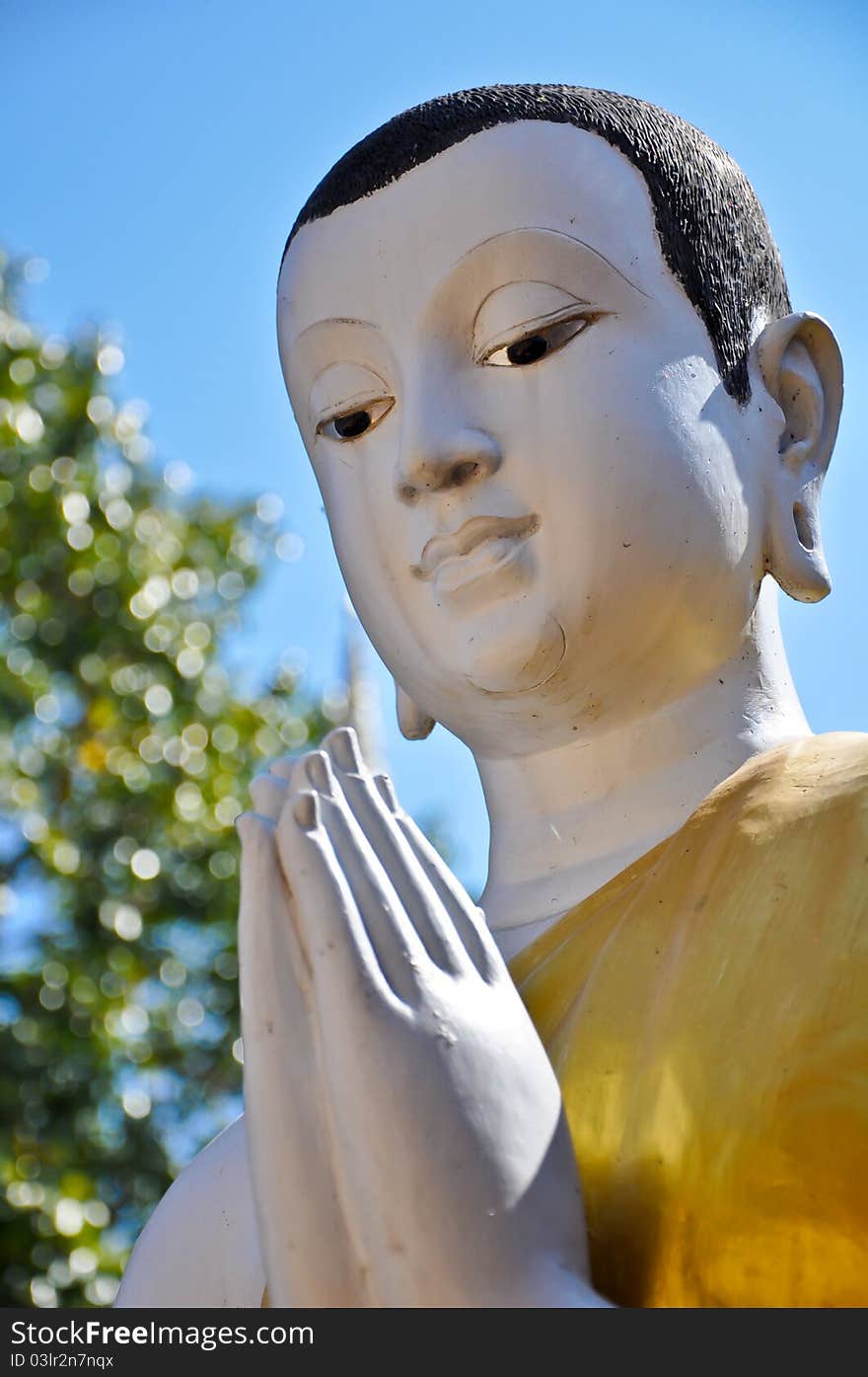 Buddist Monk statue with blue sky at Pra Sing Temple in Chiang Rai, Thailand