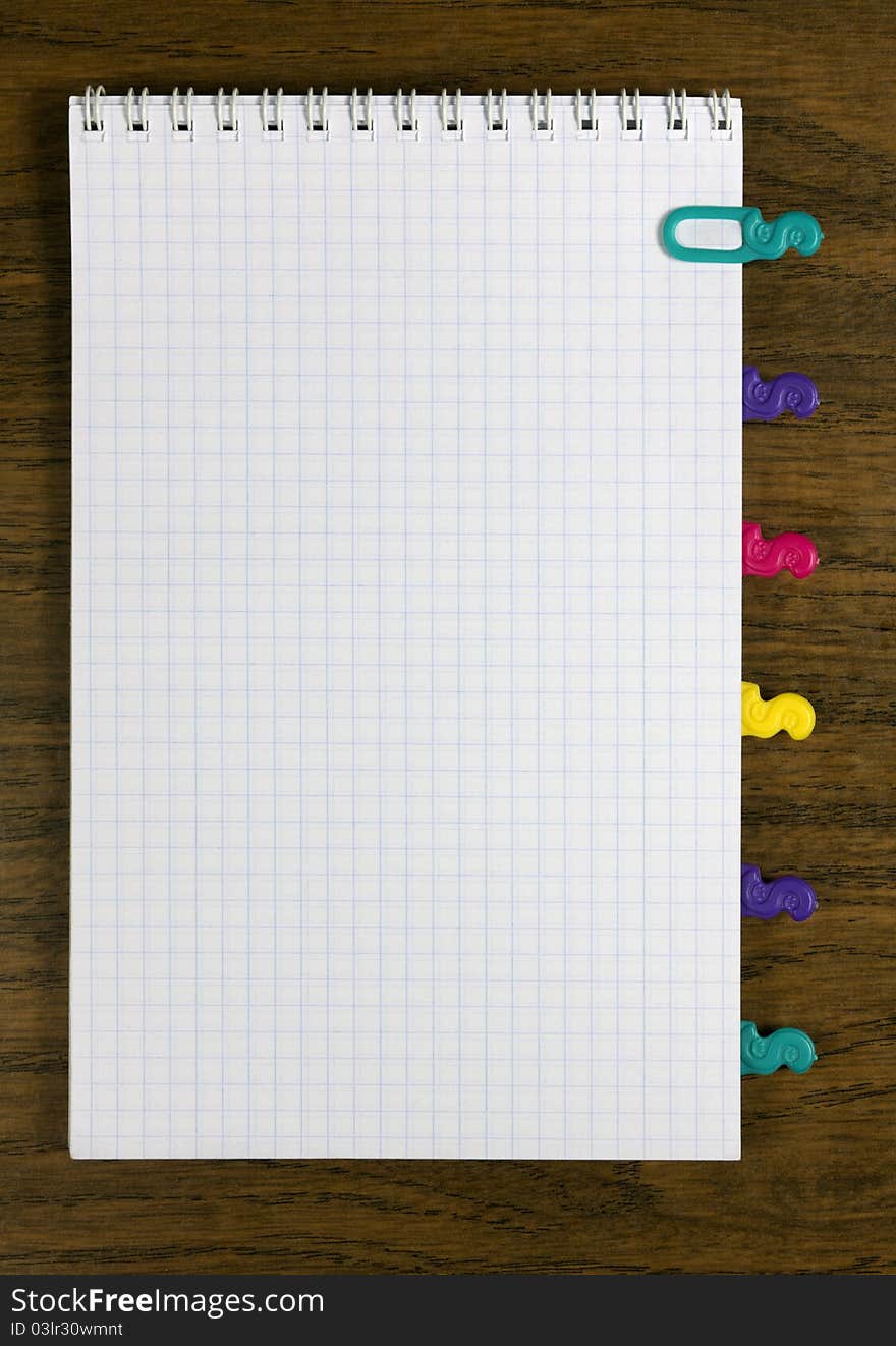 Notepad with colored tabbed on table.