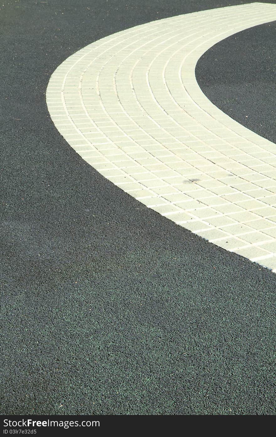 Walkway in the park with white floor on black asphalt