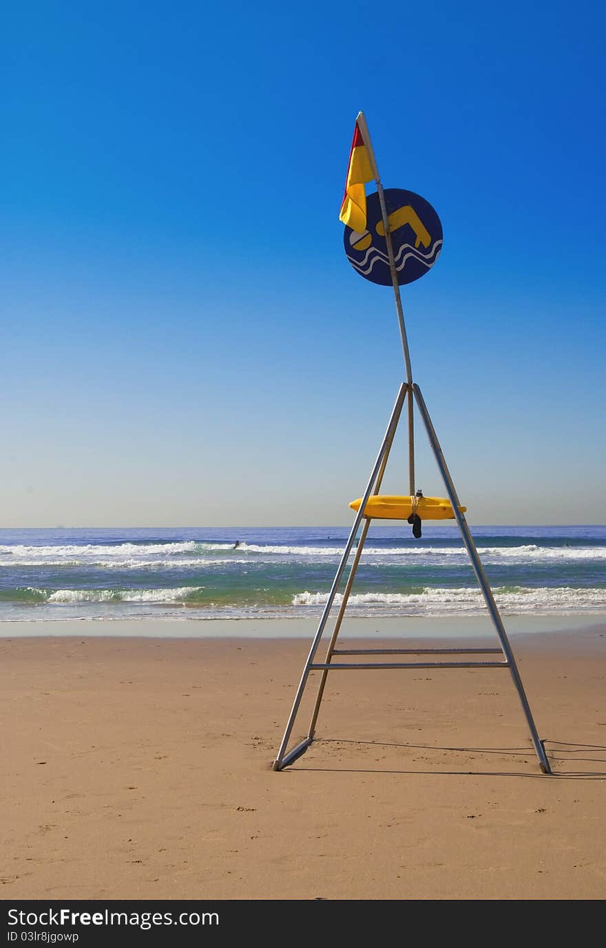 Sign indicating safe swimming zone on a deserted beach in Durban, South Africa, with golden sand blue sea and cloudless sky