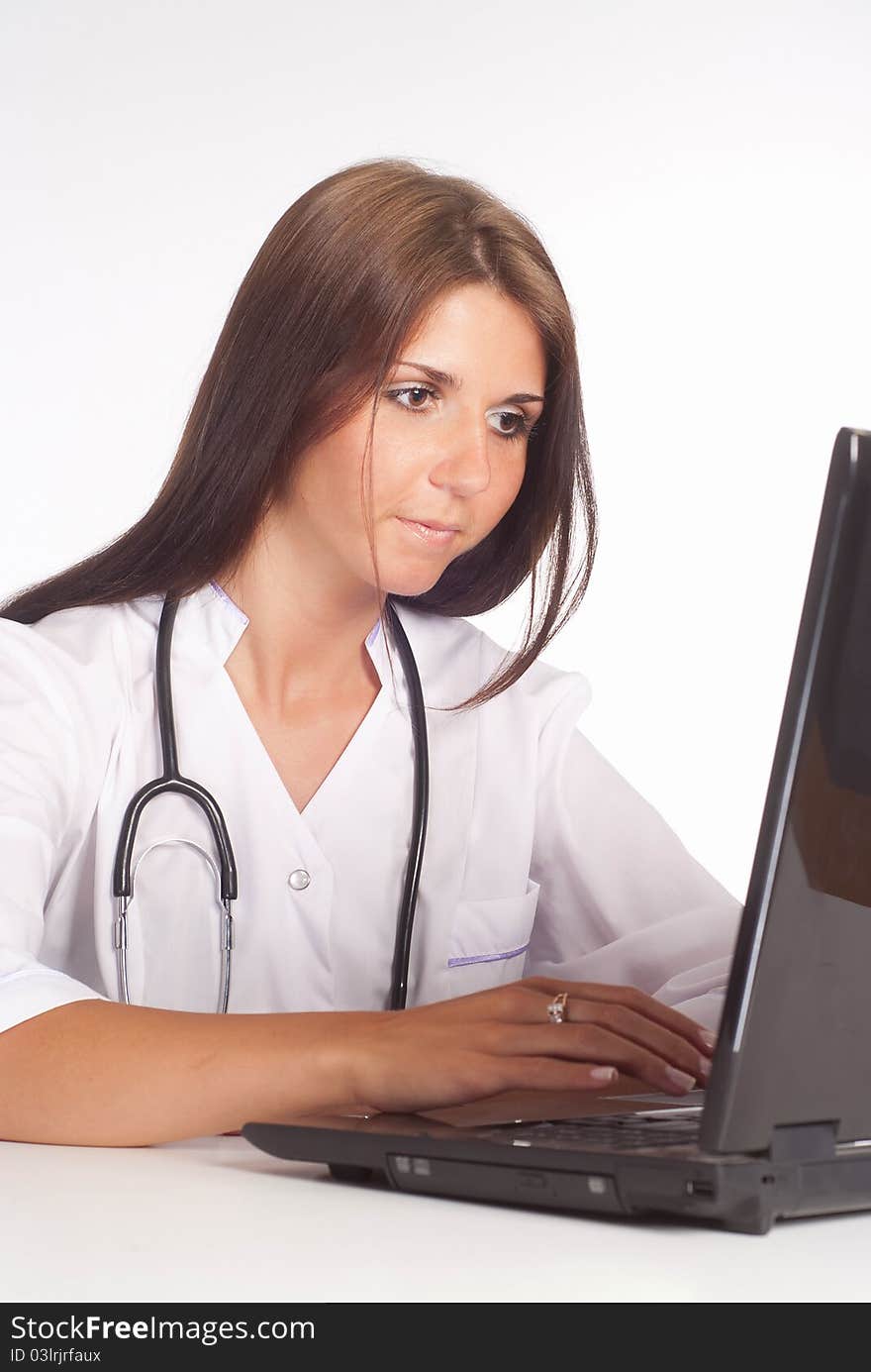 Nurse works with laptop on a white. Nurse works with laptop on a white