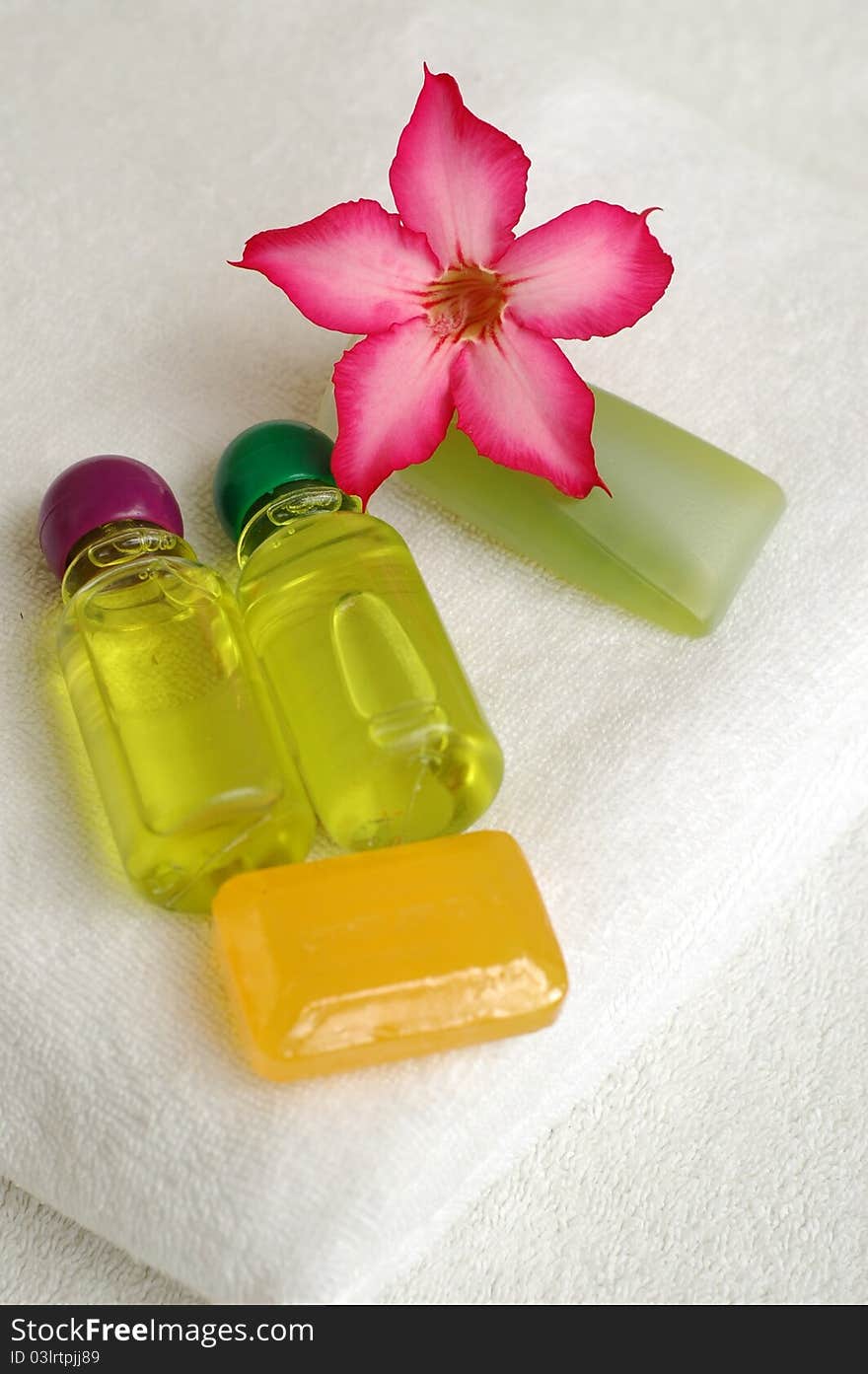 Toiletries and plumeria flower on white towel. Toiletries and plumeria flower on white towel