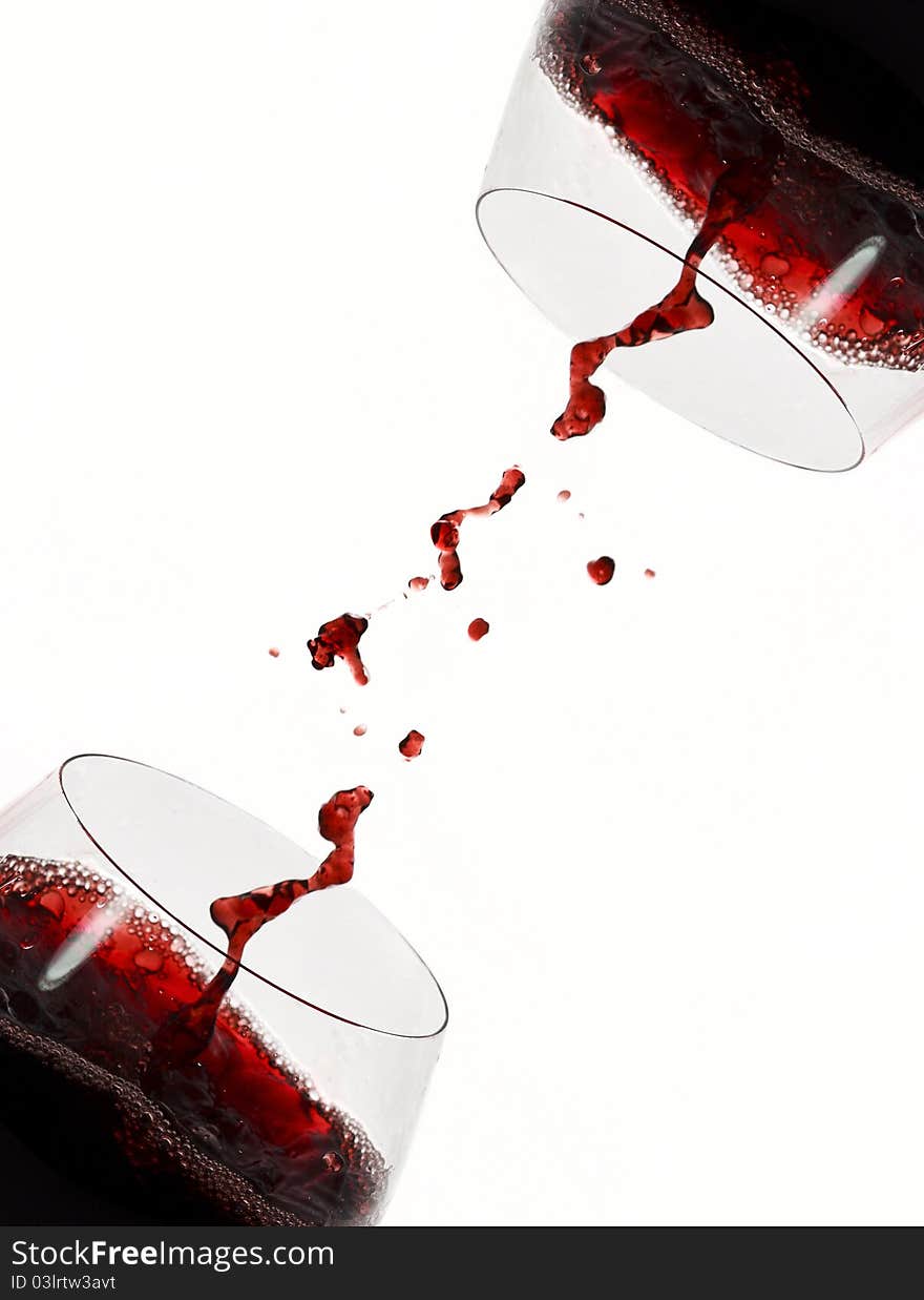 Cross full red wine glasses with red wine splash. Cross full red wine glasses with red wine splash.