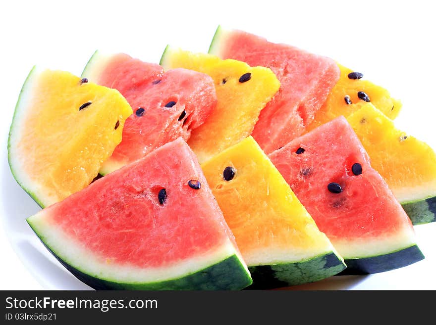 Image of sliced fresh red and yellow watermelon fruit on white plate and with white background. Image of sliced fresh red and yellow watermelon fruit on white plate and with white background.