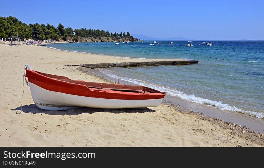 Red boat on calm beach