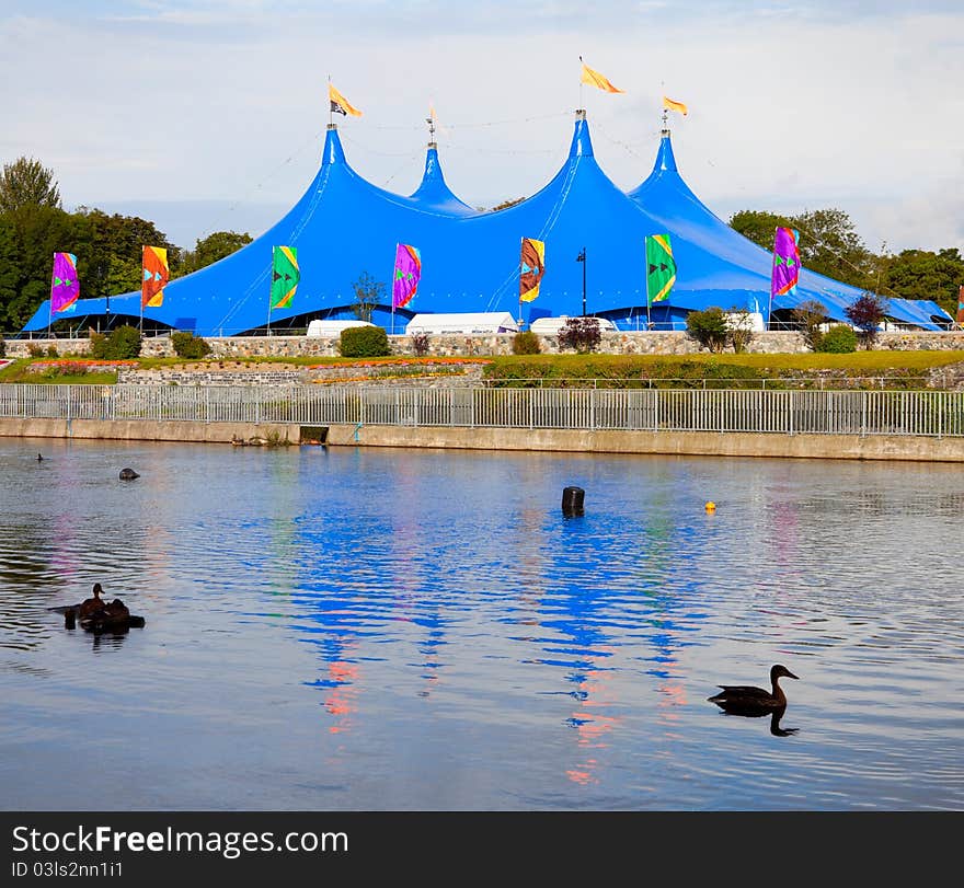 Circus style blue tent on the bank of the river