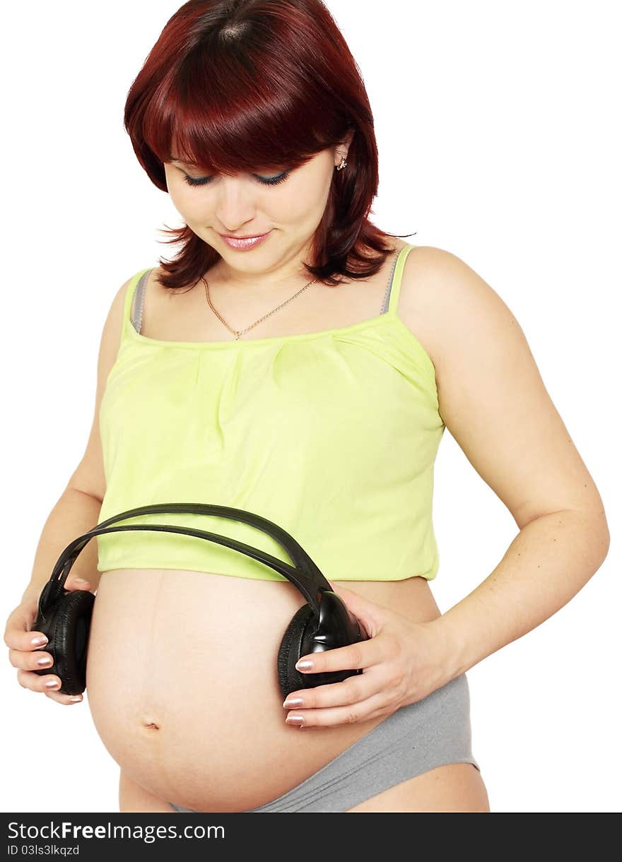 Pregnant woman holds head sets near the stomach