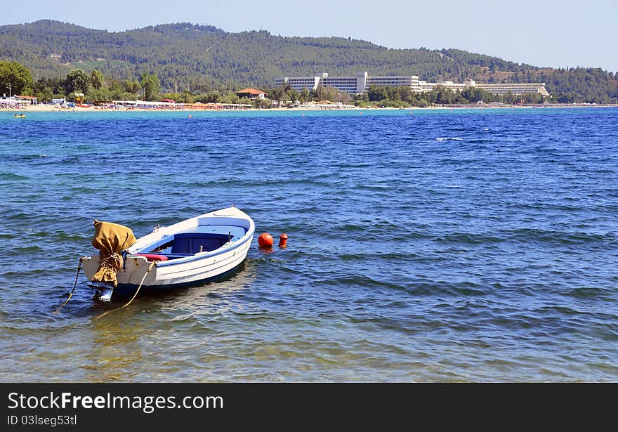 Lonely boat and modern hotel in halkidiki touristic region of greece. Lonely boat and modern hotel in halkidiki touristic region of greece