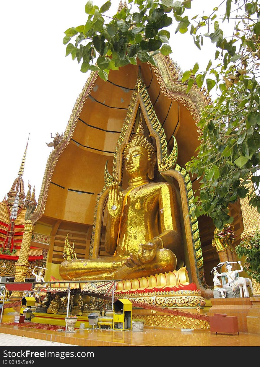 Massive golden Buddha in sitting pose with open palm in Kanchanaburi, Thailand. Massive golden Buddha in sitting pose with open palm in Kanchanaburi, Thailand.