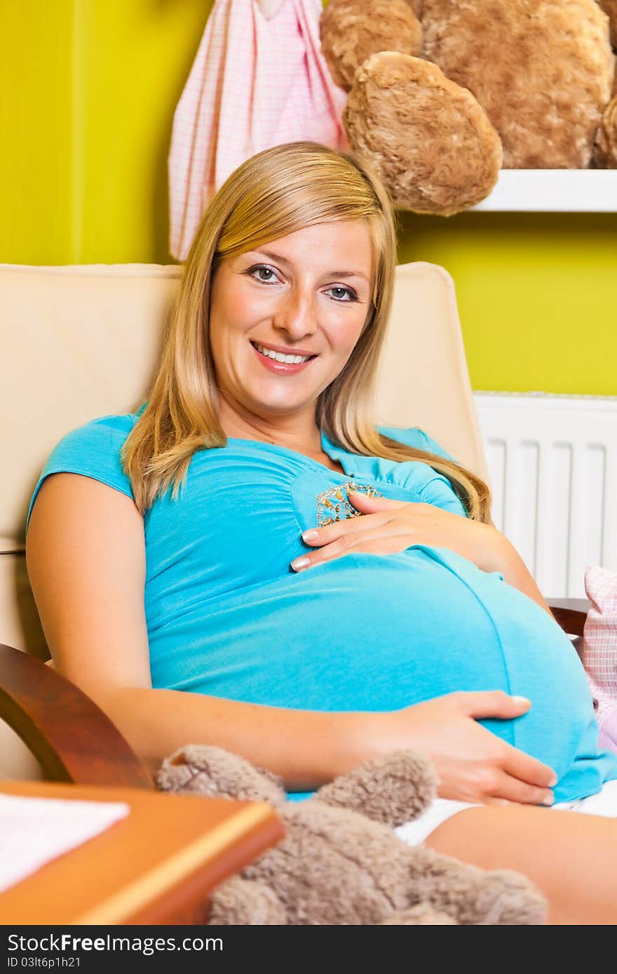 Pregnant woman in green and pink baby room. Pregnant woman in green and pink baby room