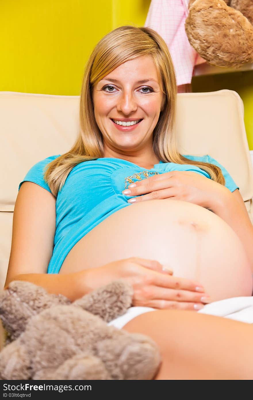 Pregnant woman in green and pink baby room. Pregnant woman in green and pink baby room