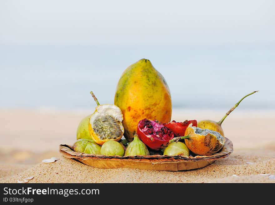 Exotic tropical fruit on the leaves plate, on the sandy beach. Exotic tropical fruit on the leaves plate, on the sandy beach