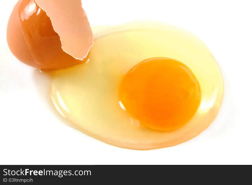 Broken egg closeup over white background