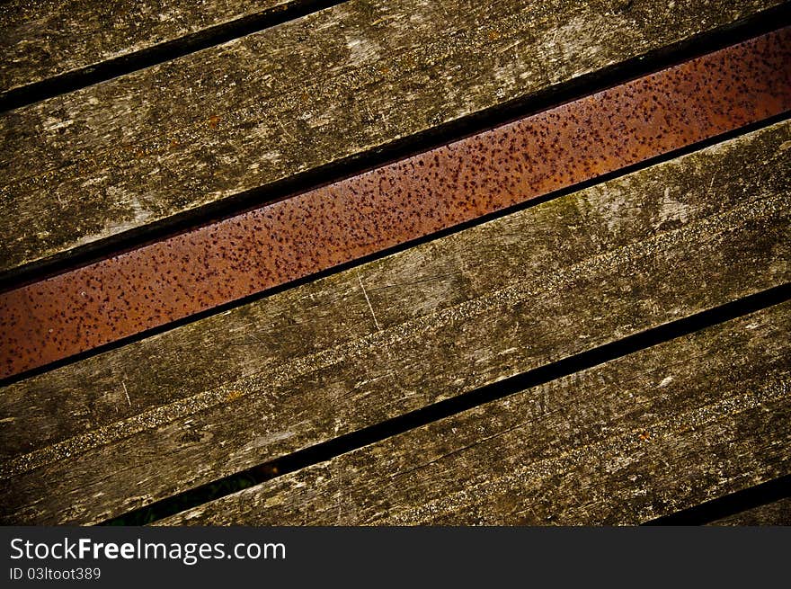 Old wooden boards on a bridge with metal beam in middle. Old wooden boards on a bridge with metal beam in middle