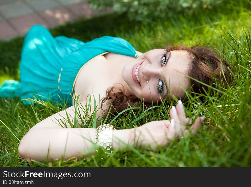 Pretty girl relaxing outdoor in green grass