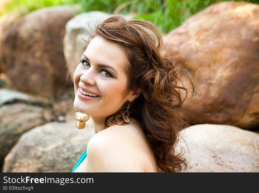 Girl with flowing hair on the background of rocks