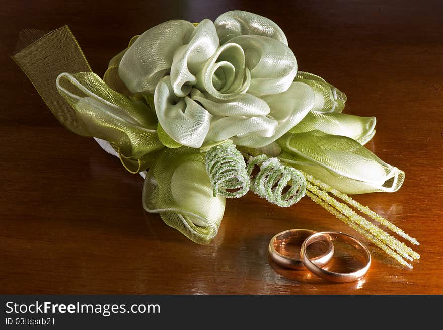 Wedding favors and wedding rings on a dark wood table