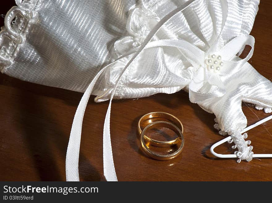 Wedding favors and wedding rings on a dark wood table