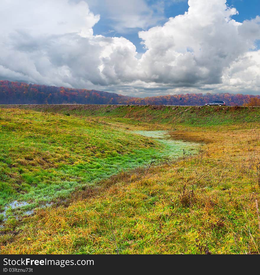 Colorful autumn landscape with vehicle