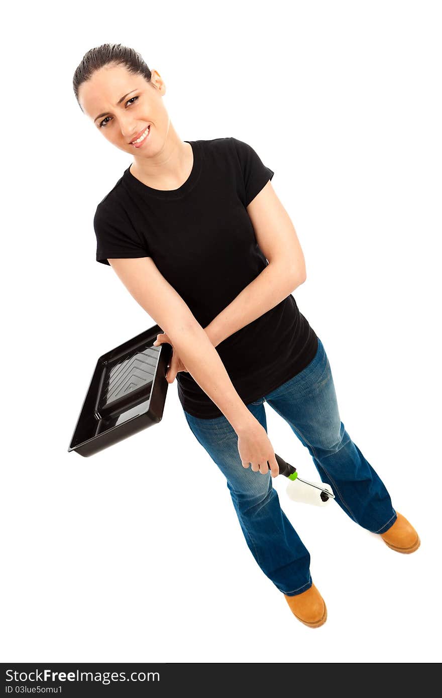 A young female dressed in a black t shirt and blue jeans holding a paint roller and tray. A young female dressed in a black t shirt and blue jeans holding a paint roller and tray