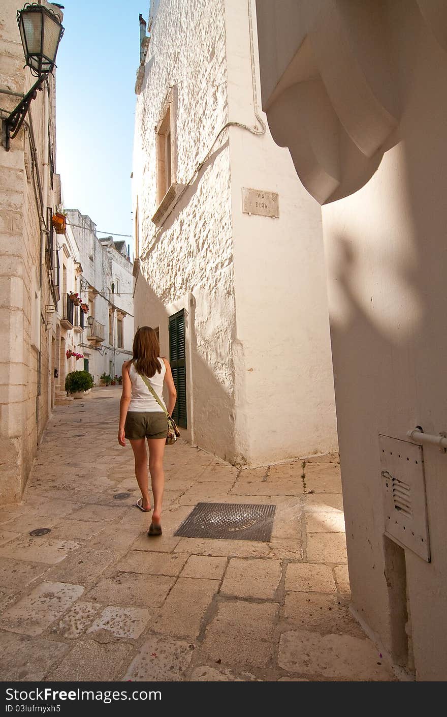 Girl walking along a narrow street. Girl walking along a narrow street