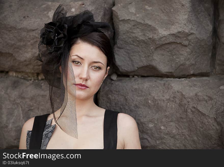 Retro-stylized woman in black hat with veil and black dress.