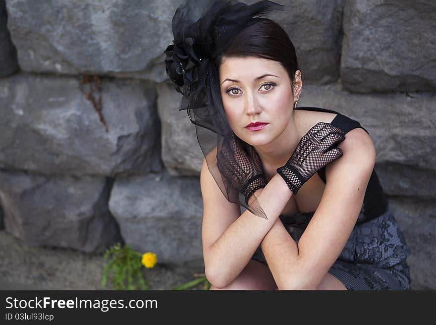 Retro-stylized woman in black hat with veil and black dress.